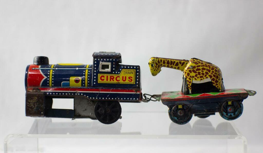 Close-up of giraffe carriage showing yellow giraffe figure on red and green lithographed base.