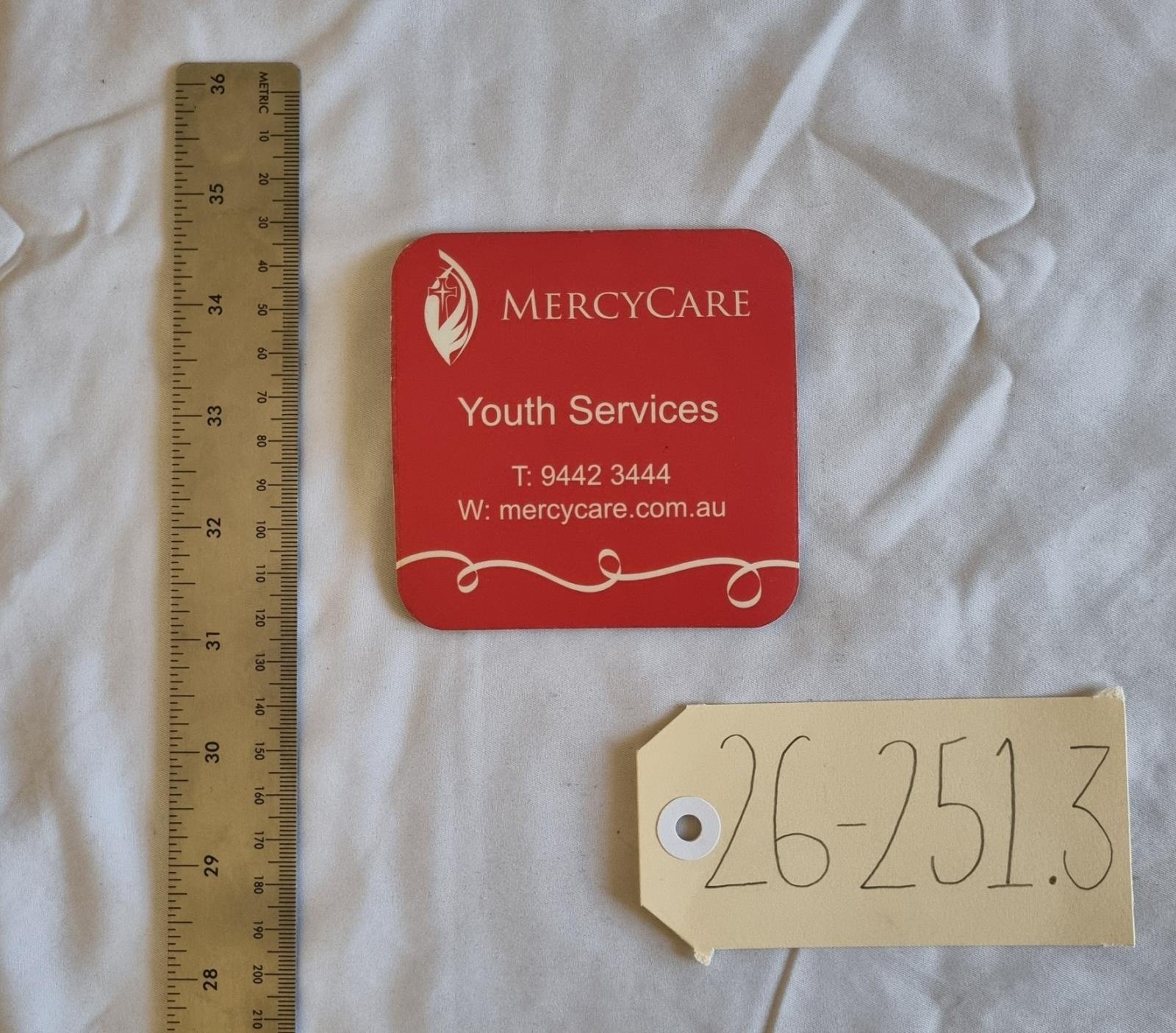 26-251.3 Coaster with MercyCare Old Logo photo with scale and tag. 