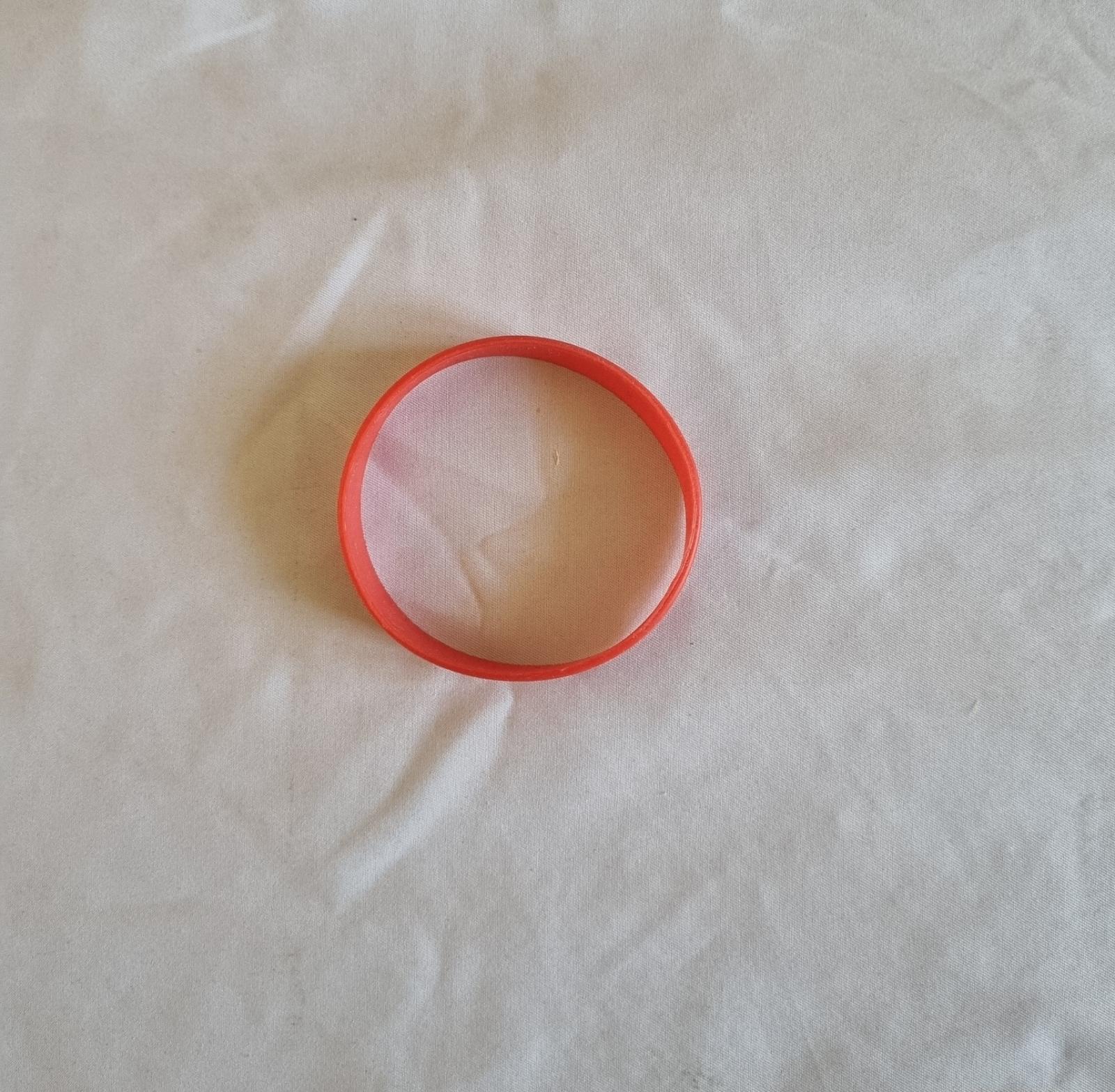 26-251.6 Red Wristband with old MercyCare logo photo with background top-view.