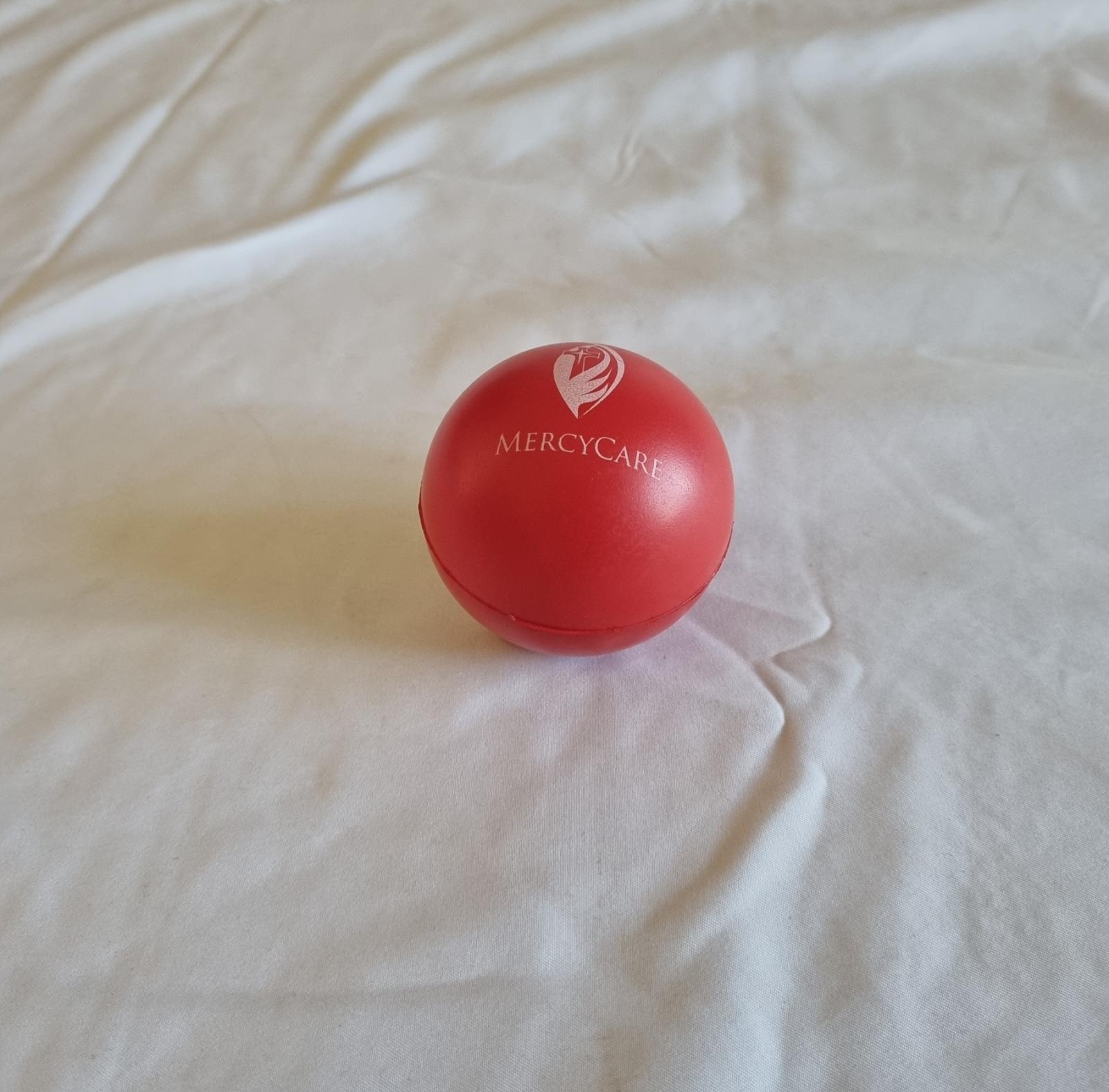 26-251.7 Red Foam Stress Ball with MercyCare Old Logo photo with background. 