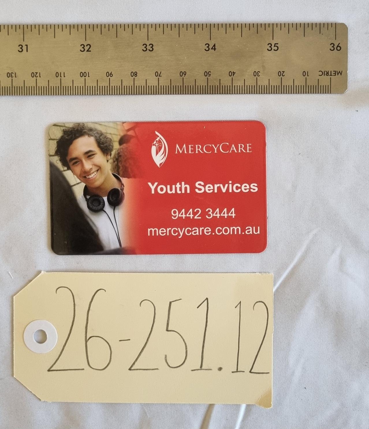 26-251.12 MercyCare Business Card photo with scale and tag.