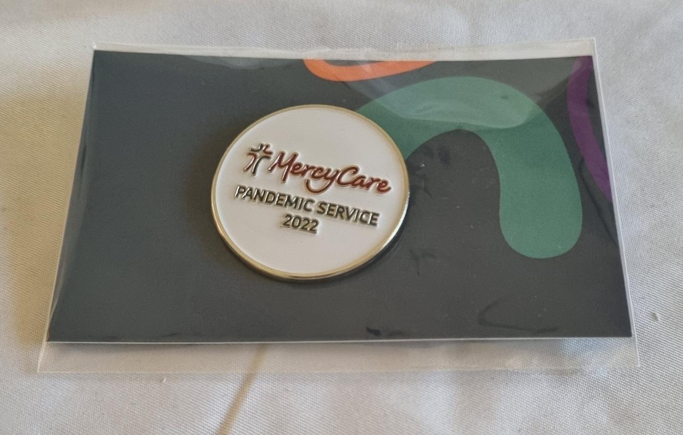 26-254 MercyCare Pandemic Service Badge photo with background front-view.