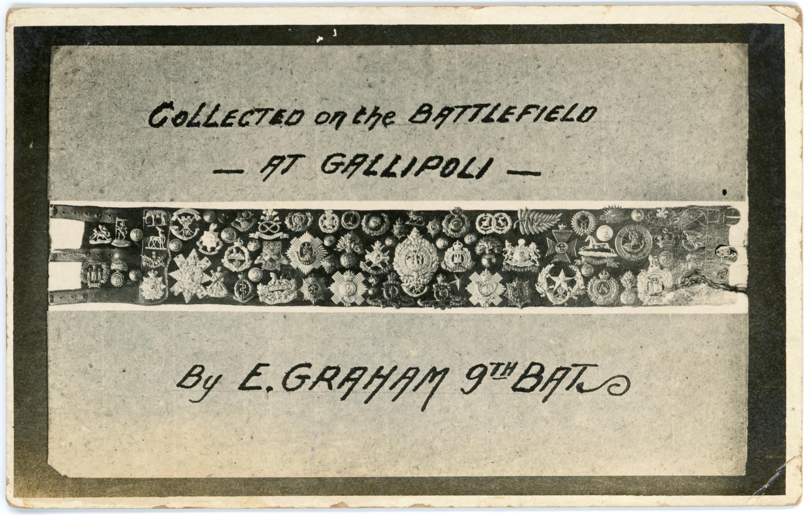 Postcard showing a belt with numerous military badges and buttons attached.