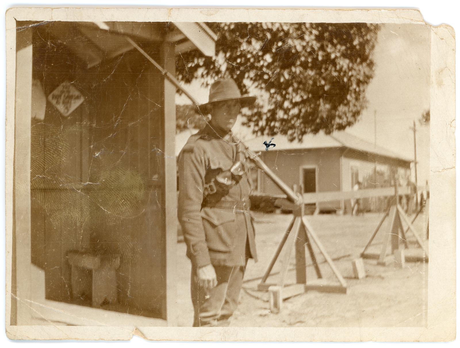 Photo showing Pte. Eric BANNISTER in uniform and armed, standing outside sentry box.
