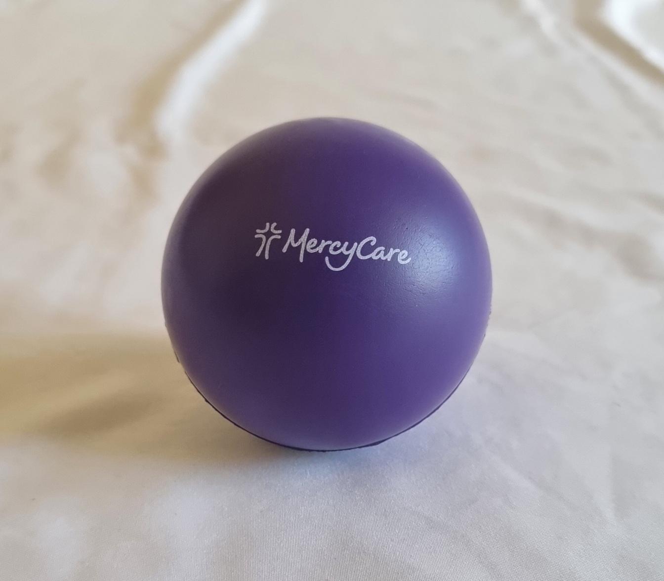 26-258 Purple Stress Ball with new MercyCare Logo photo with background. 