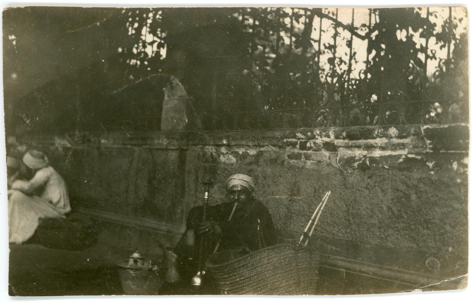 Photo of Egyptian man smoking a 'Hookah pipe' in the street of Cairo.