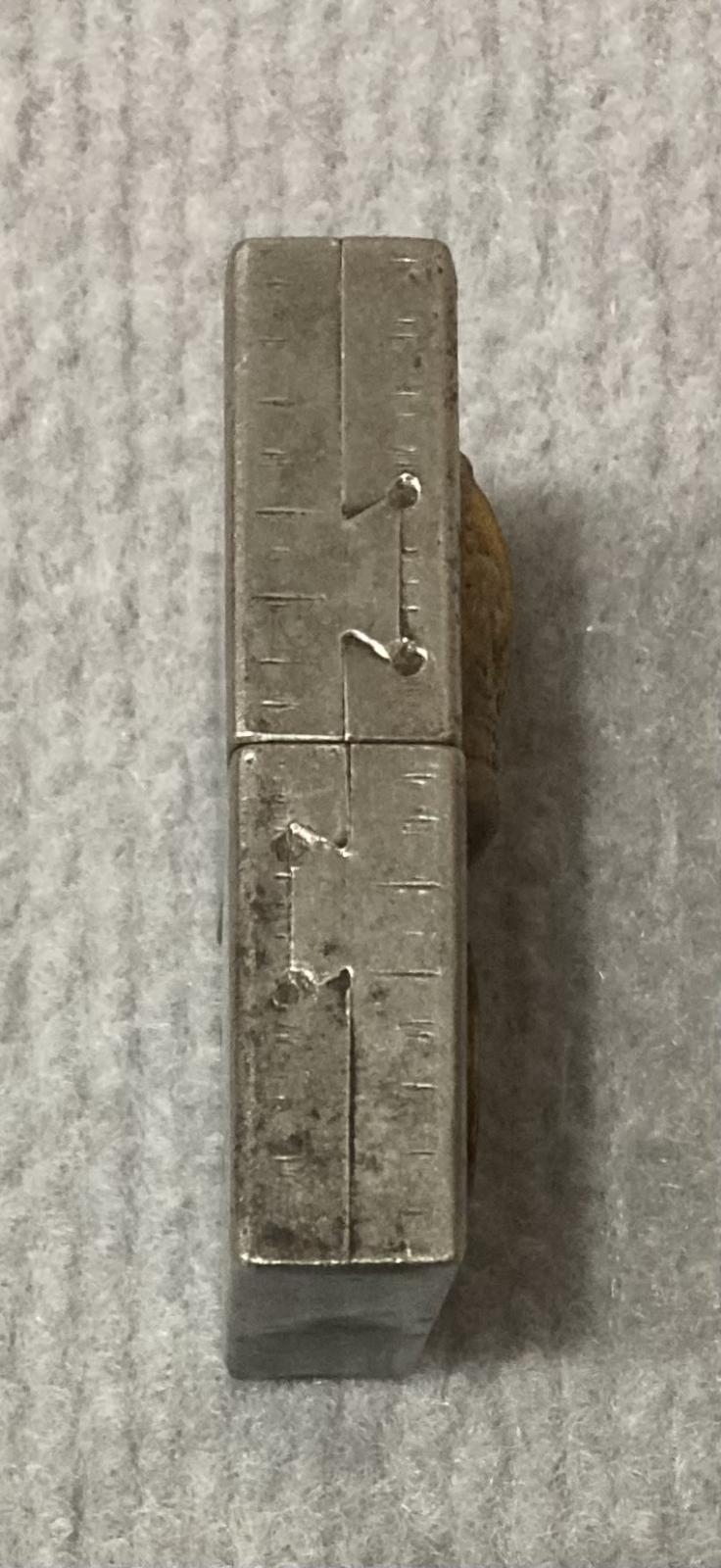 Left side view of metal lighter with attached rank badge and coin