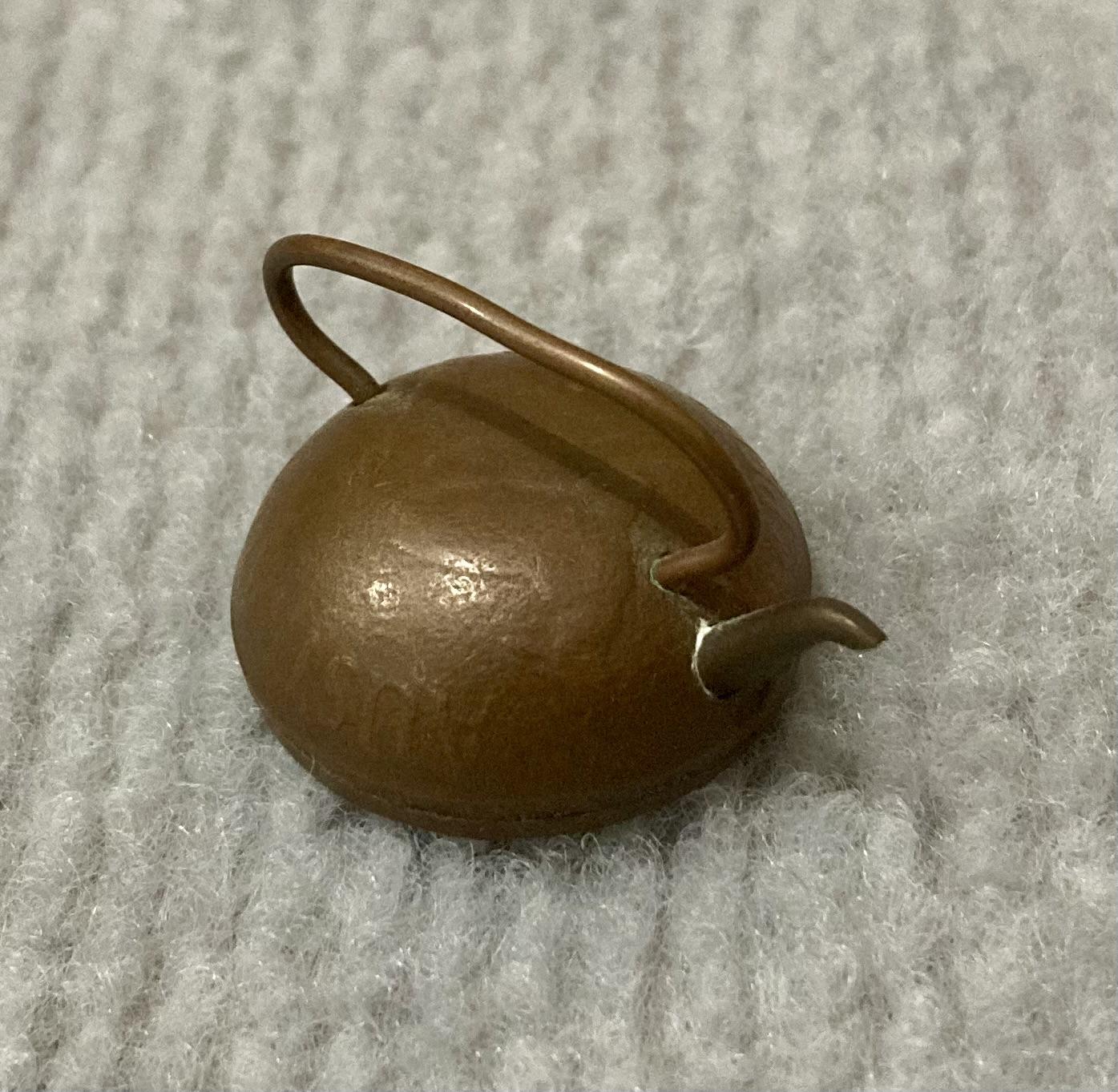 Angled view of miniature tea kettle made from Australian coin