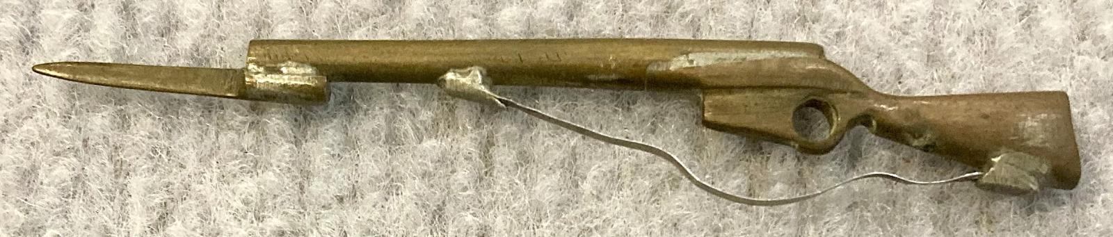 Other side of miniature brass rifle with bayonet and sling