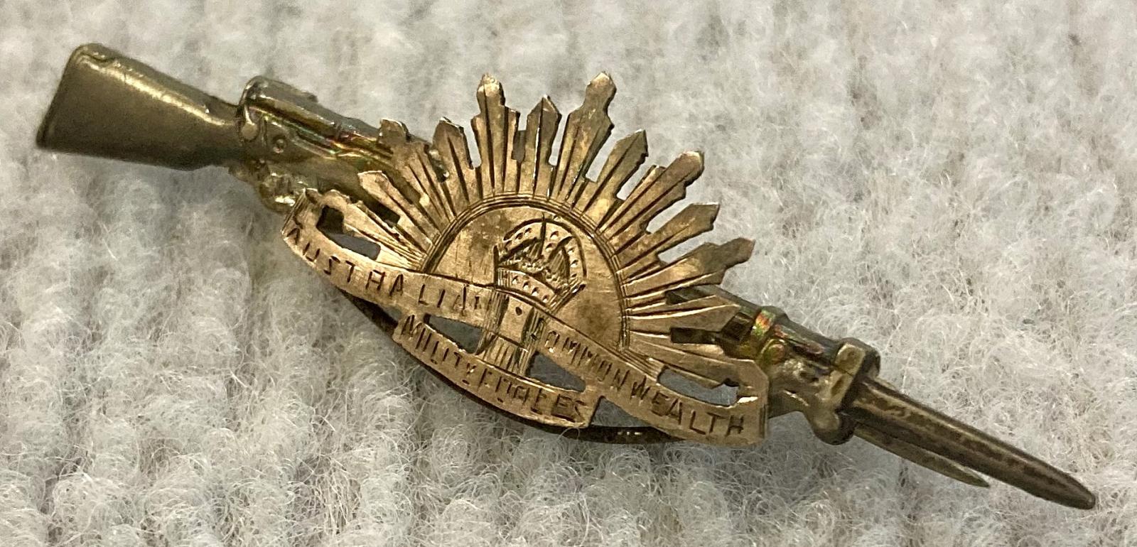 Other angled view of sweetheart brooch with Rising Sun badge attached to rifle and bayonet
