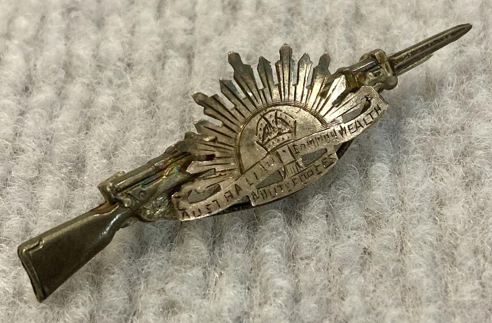 Angled view of sweetheart brooch with Rising Sun badge attached to rifle and bayonet