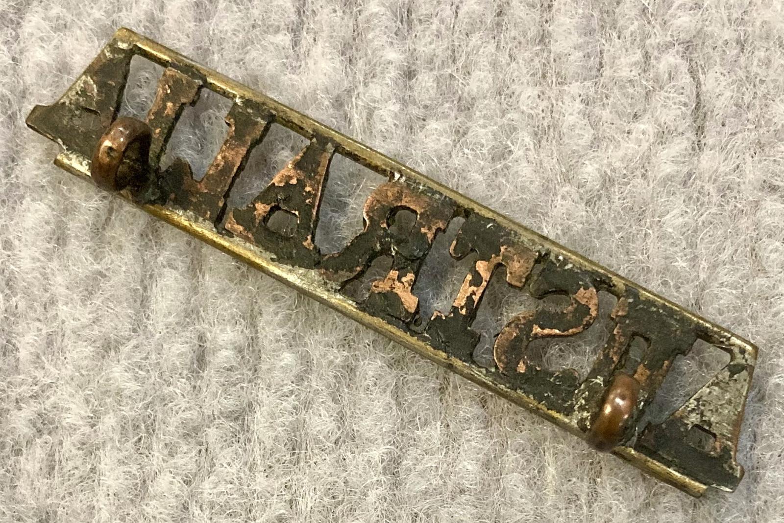 Angled view of reverse of straight Australia metal shoulder title