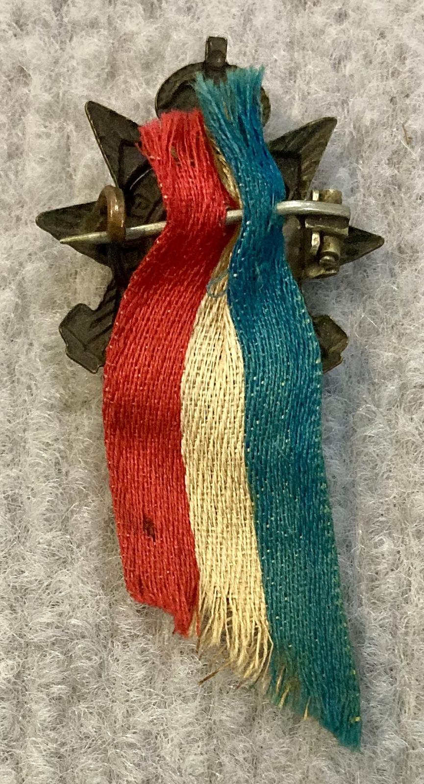 Reverse of Australian Engineers collar badge with attached patriotic ribbon