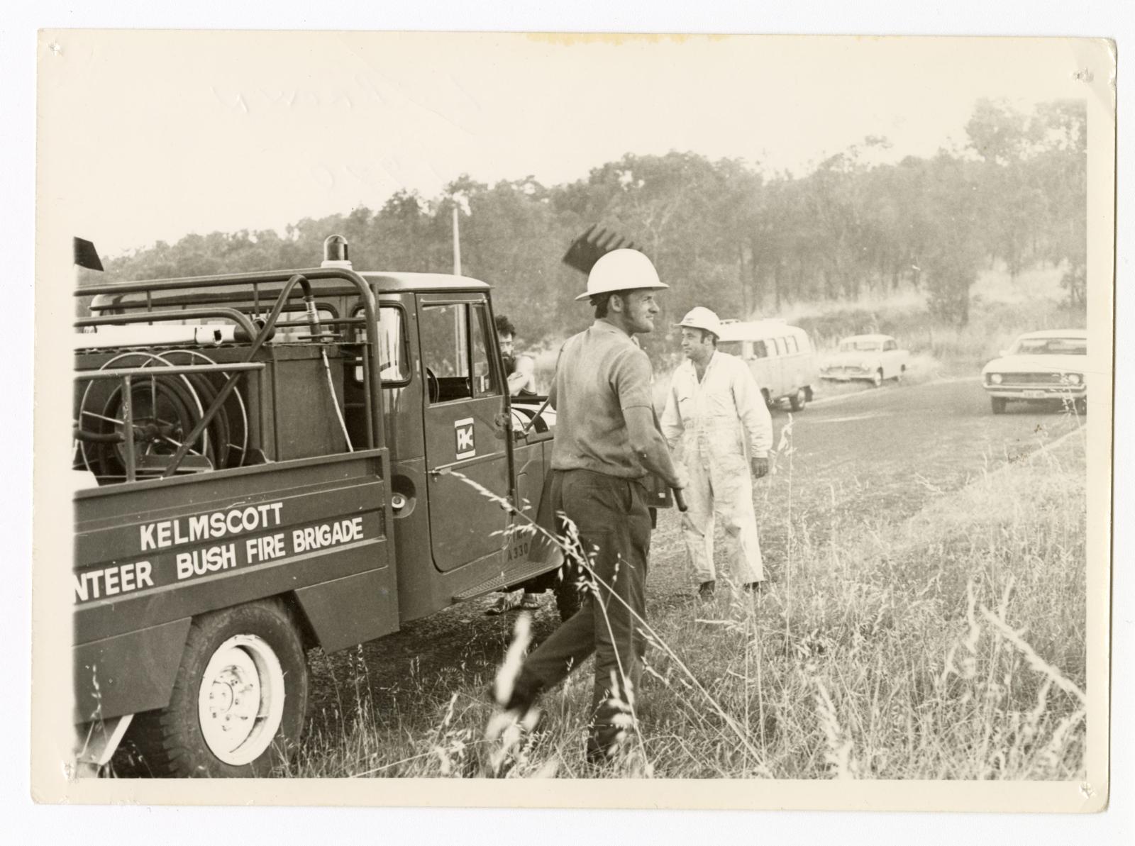 Neville Voysey (right) and Lionel Brown (holding rake) from the Kelmscott Volunteer Bushfire Brigade attending a burn off with the first Kelmscott Unit vehicle, c1974.