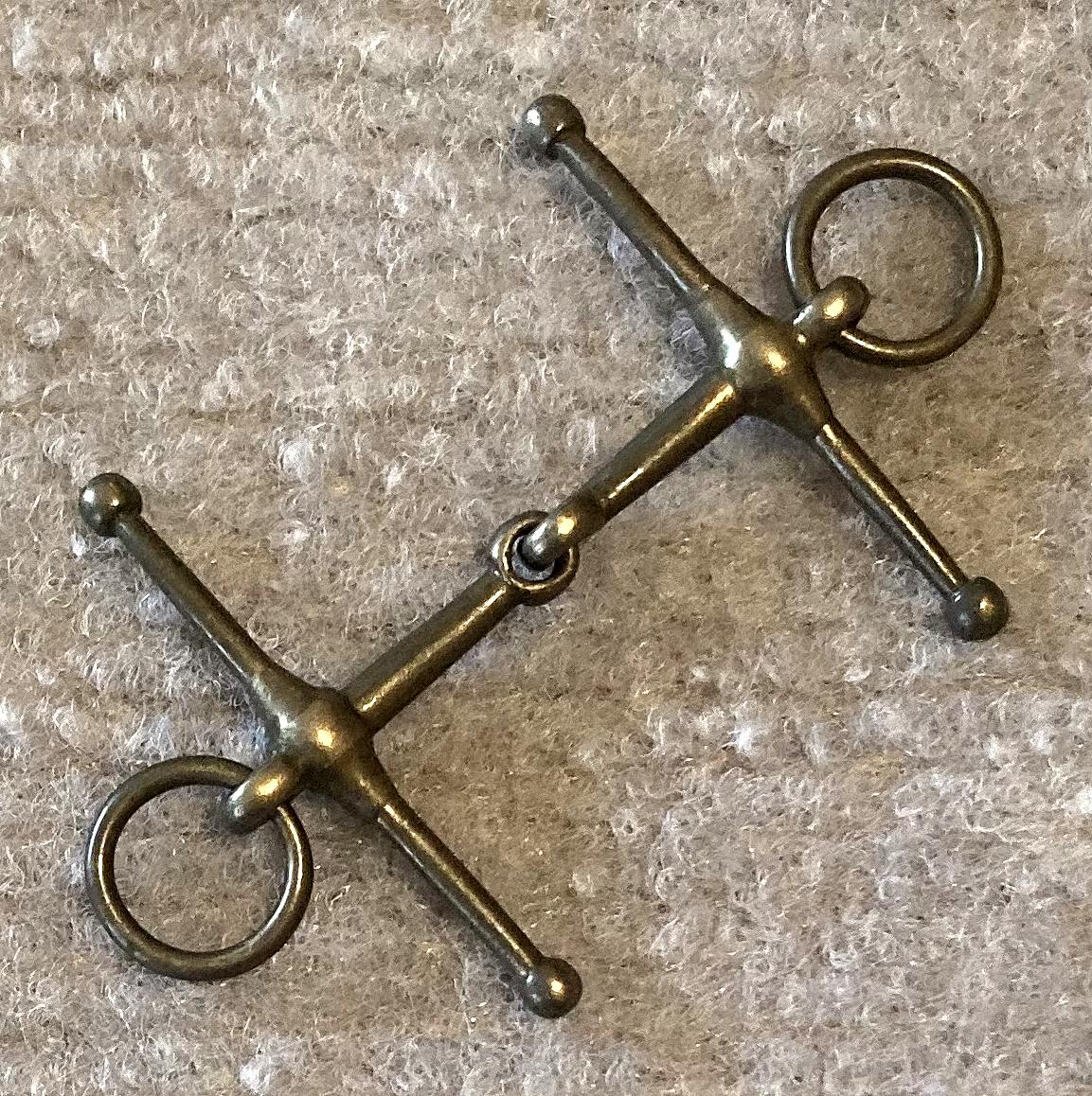 Angled view of miniature metal full cheek, loose ring, snaffle horse bridle bit