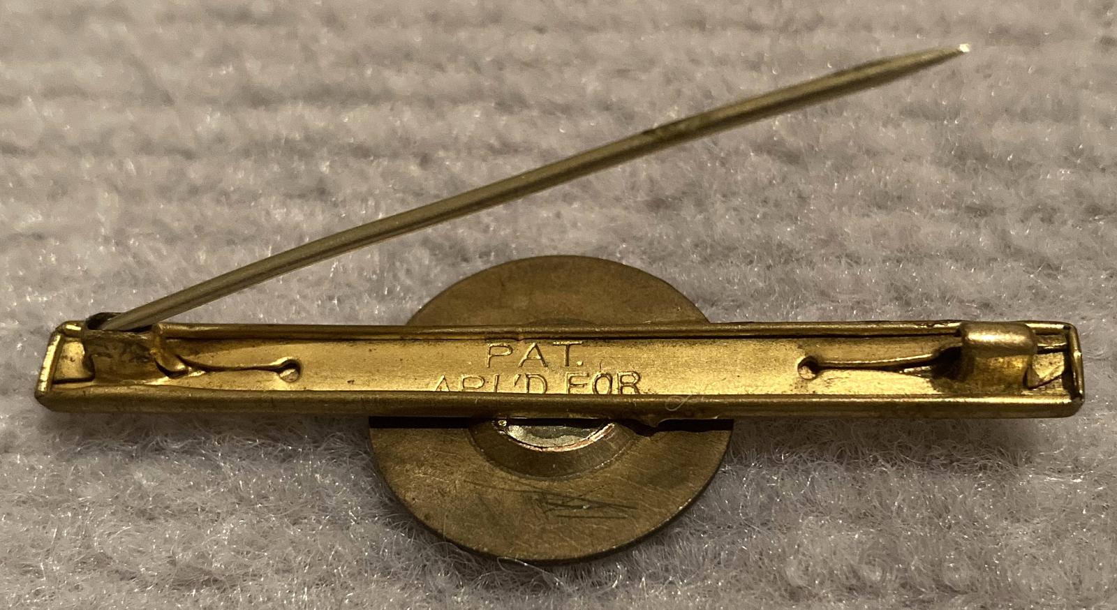 Reverse of 'Lest we forget ANZAC' tie or lapel pin showing writing