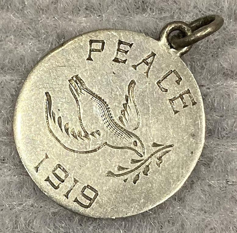 Angled view of Silver Peace medallion featuring dove carrying olive branch - 1919