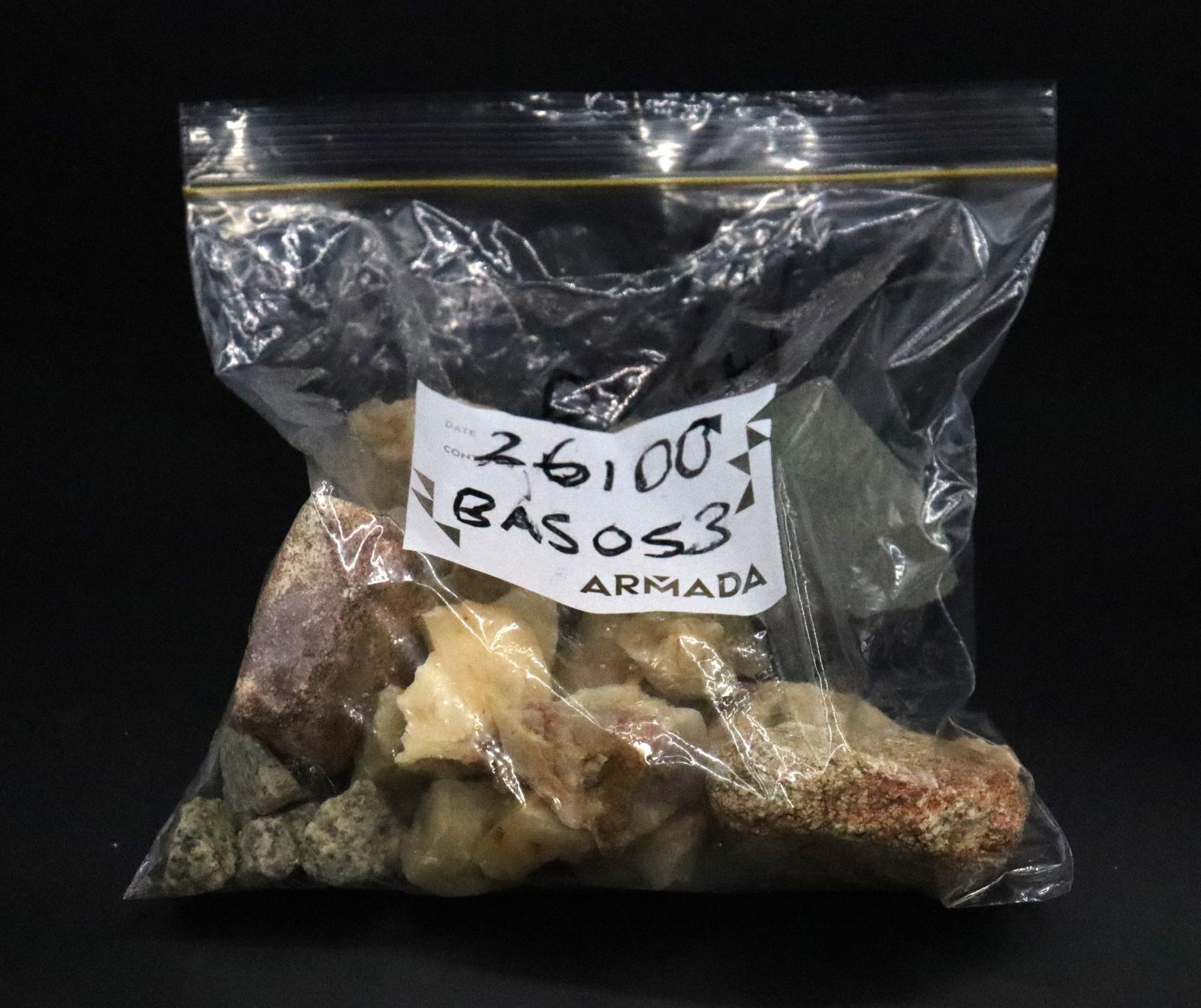 The bag is half filled with a mixed collection of small and large stones/rocks of varying colours and shapes. 