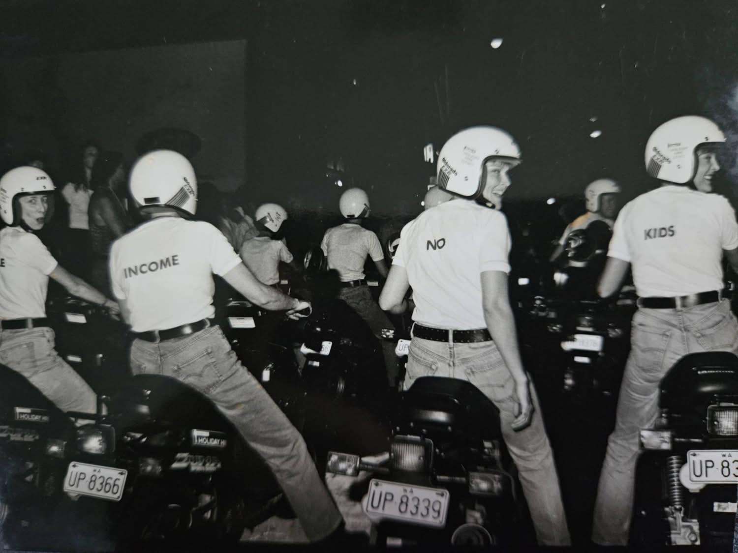 black and white photo of people on motorbikes