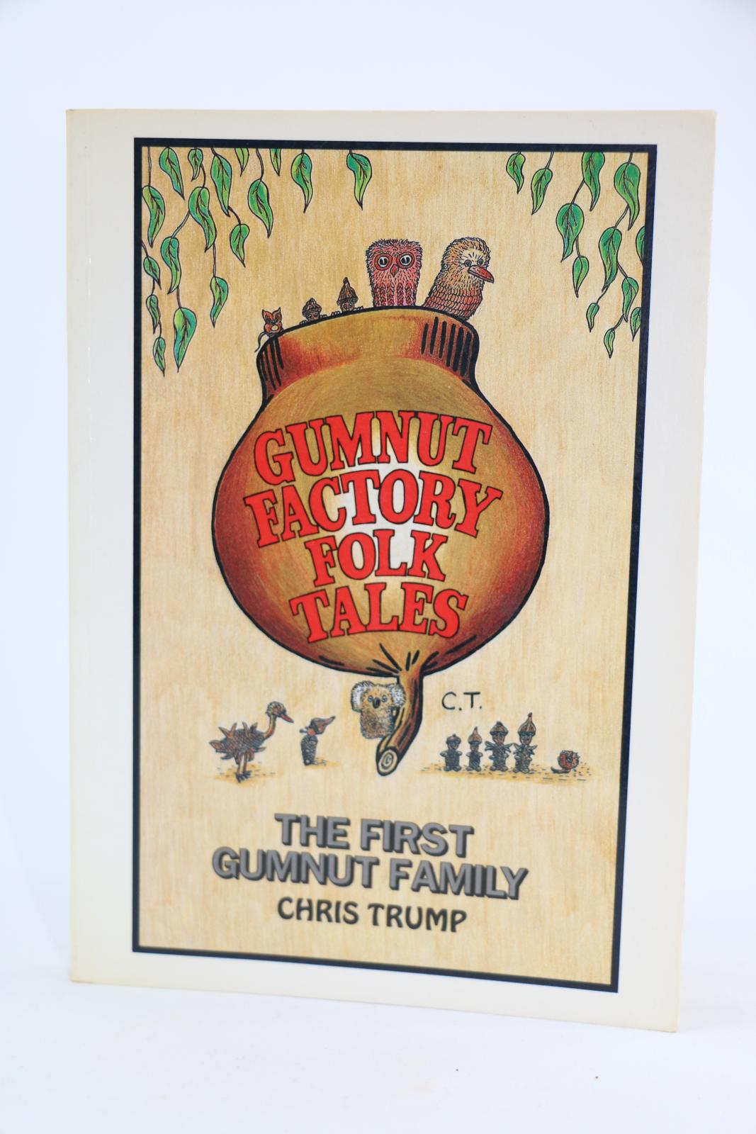 There is an image on the front cover of a large gumnut with 'Gumnut Factory Folk Tales' written in red. Some of the gumnut figures from the stories are surrounding the bottom of the gumnut and other are coming out from the top. In the top left and right corners of the book ae green tree leaves. At the bottom of the page is 'The First Gumnut Family/ Chris Trump'.