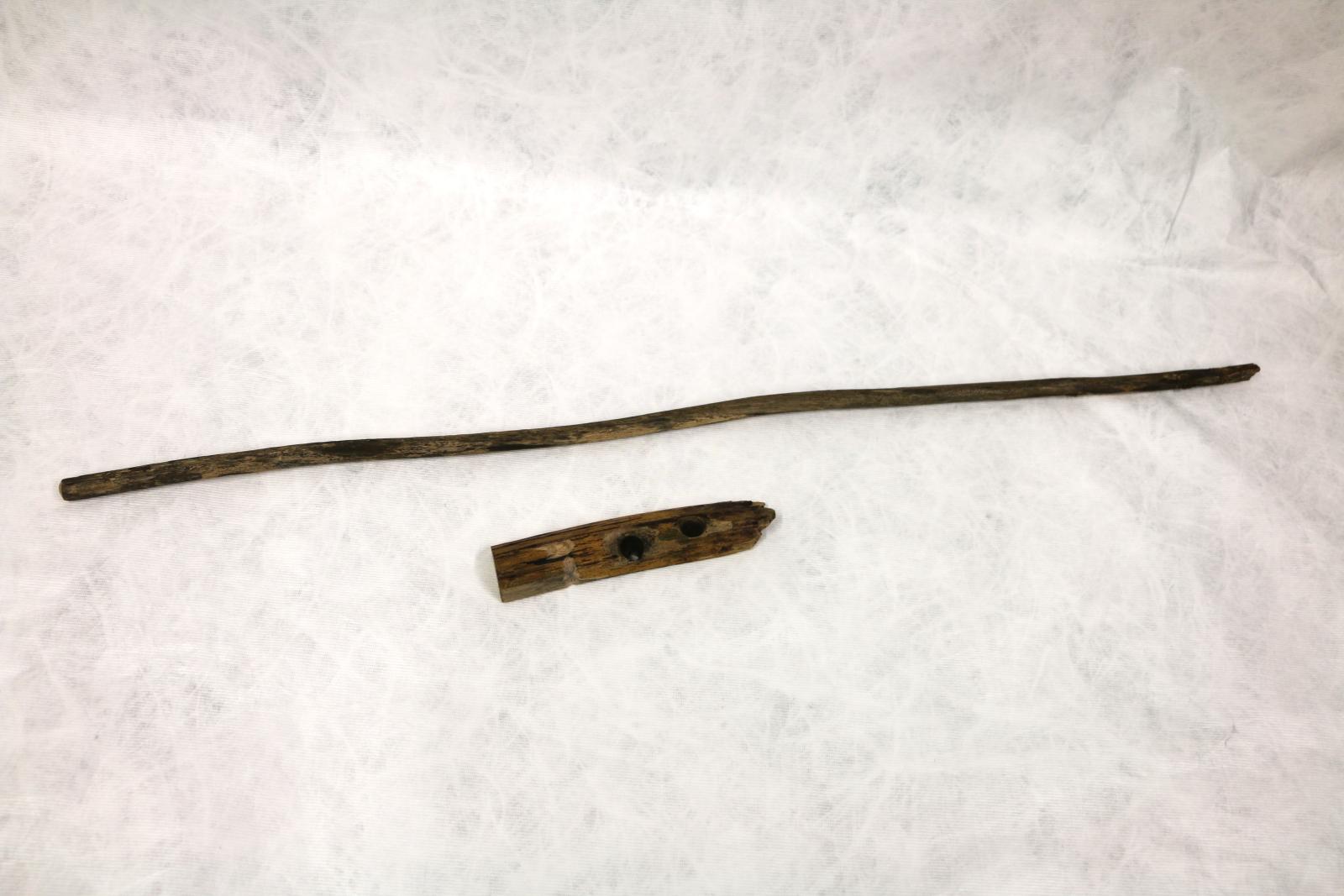 Fire Stick - Long thin branch from a Balga tree. Light fraying of bark in centre. Light and dark brown. Small circular cavities at one end (non drill end). Hearthboard - Short, thick branch, cut in half, one flat edge (bottom), one curved edge (top). The top has two well defined holes, the middle hole goes all the way through the branch. Light and dark brown wood. LHS small indent and groove to the bottom.