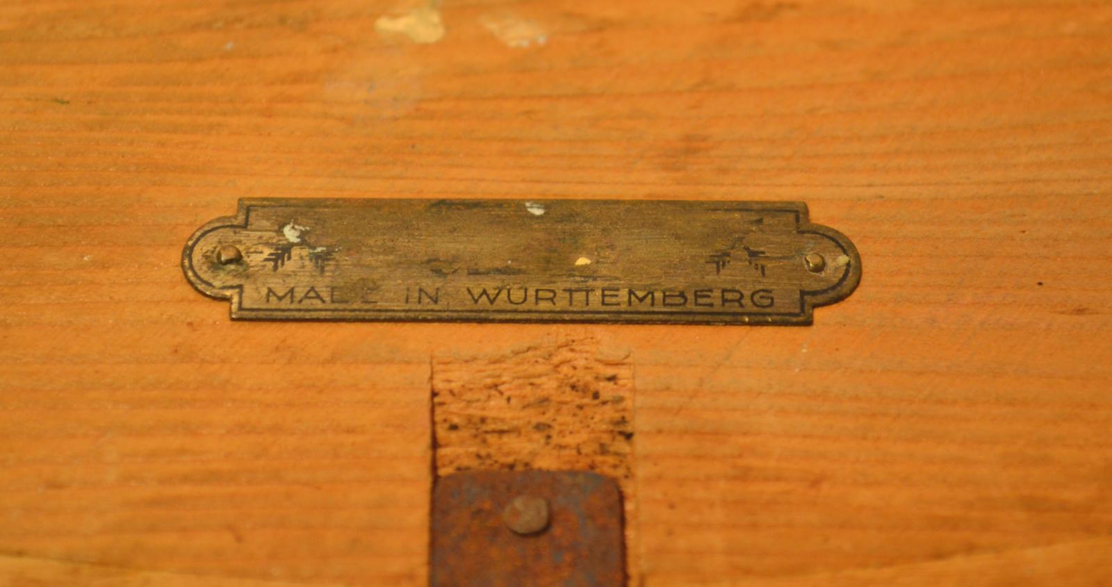 The small, metal plate on the back of the clock stating that the clock was manufactured in Wurttemburg.