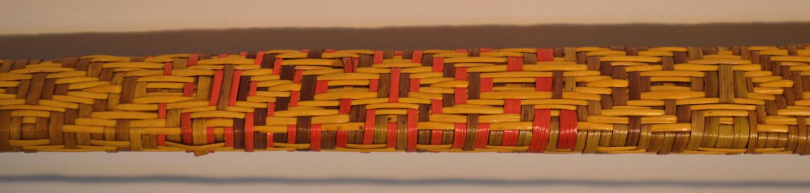 The wooden bow's ornate woven pattern of very thin fibres.