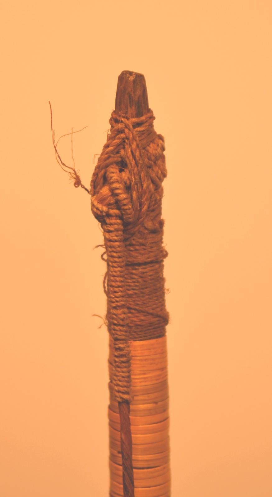 The end of the bow, where the string is bound to wood in an intricate knot.