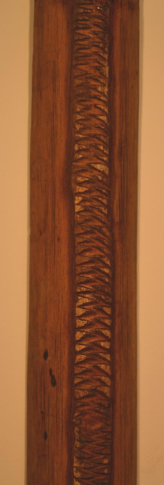 A serrated tooth pattern along the length of the wooden bow.