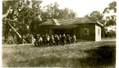 A group of people sitting on benches outside of the Kelmscott Infant Health Centre