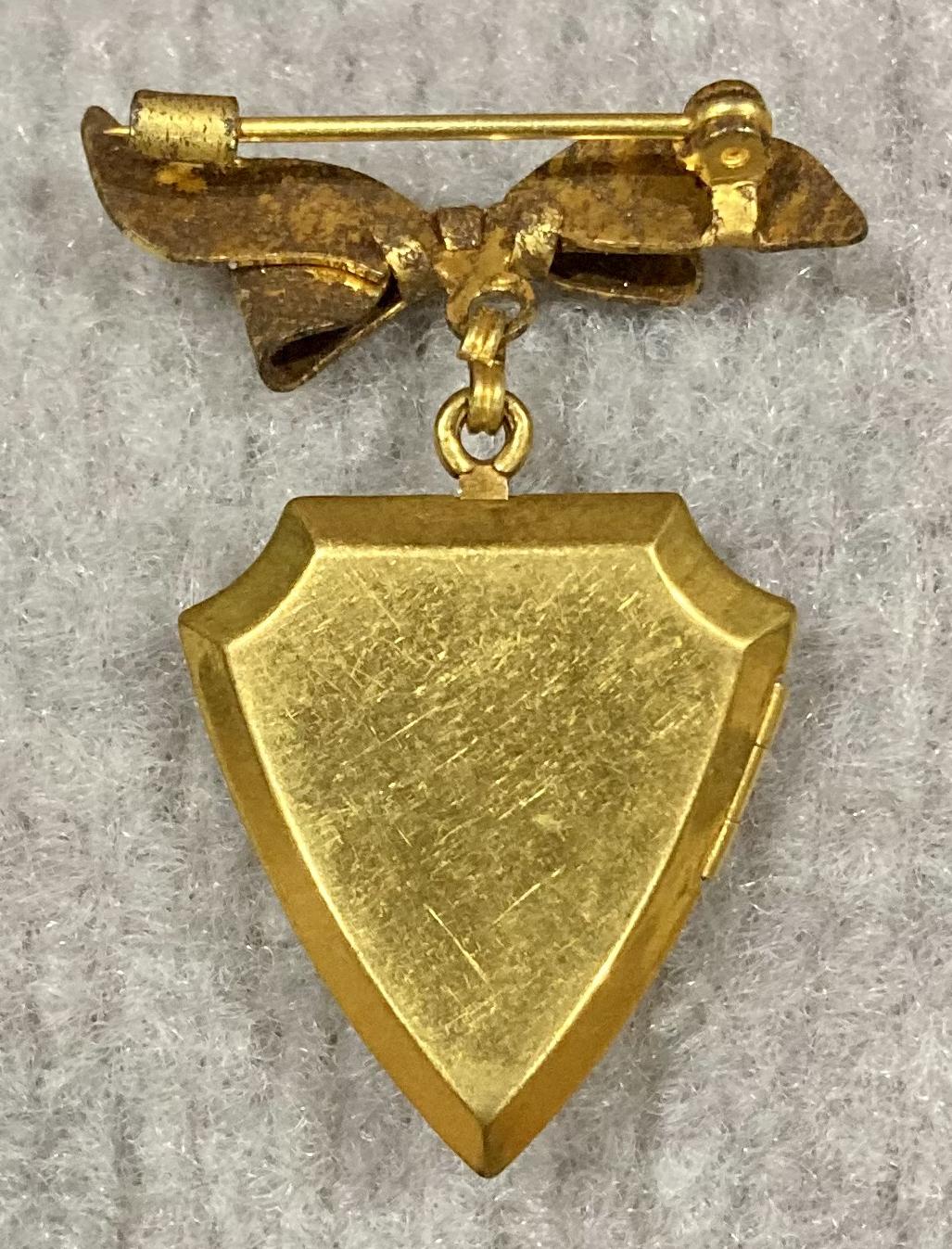 Reverse of United States Army Air Force gold tone locket suspended from bow