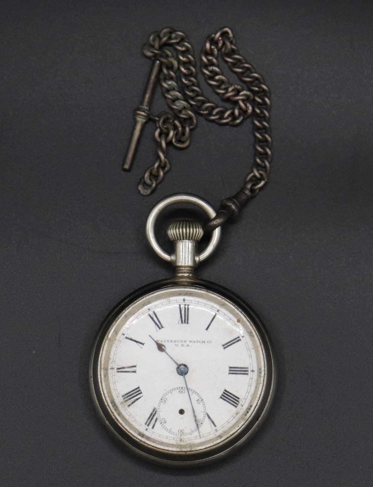 Round silver plated pocket watch with a white face and black Roman numerals.