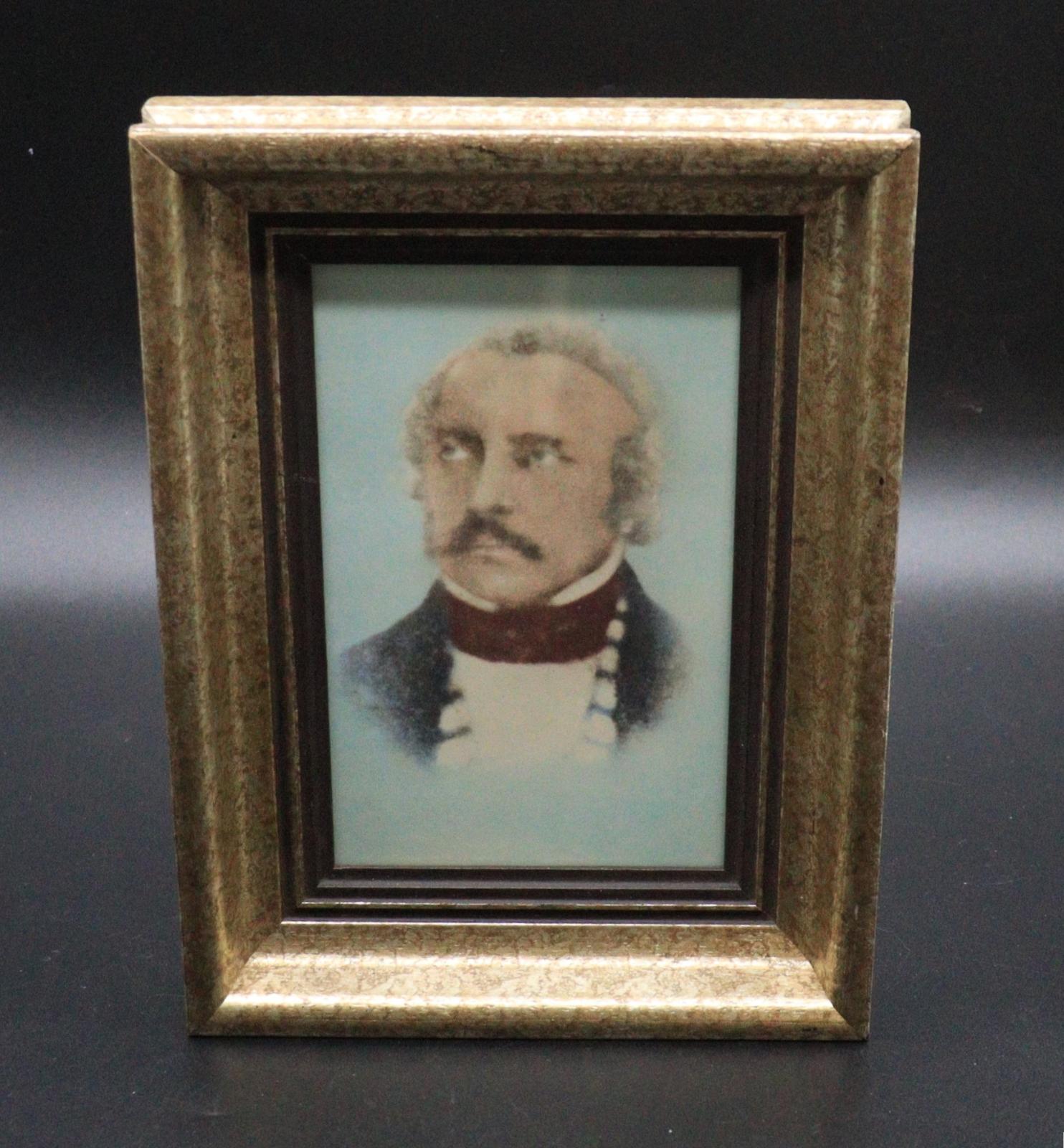 A portrait of the bust of Henry Hall on a light blue background. He has a receding grey hairline with a dark drooping moustache and is looking up. He is wearing a maroon coloured cravat over a white shirt with a high collar under a dark jacket. The picture is mounted in a gold speckled frame with a brown border.