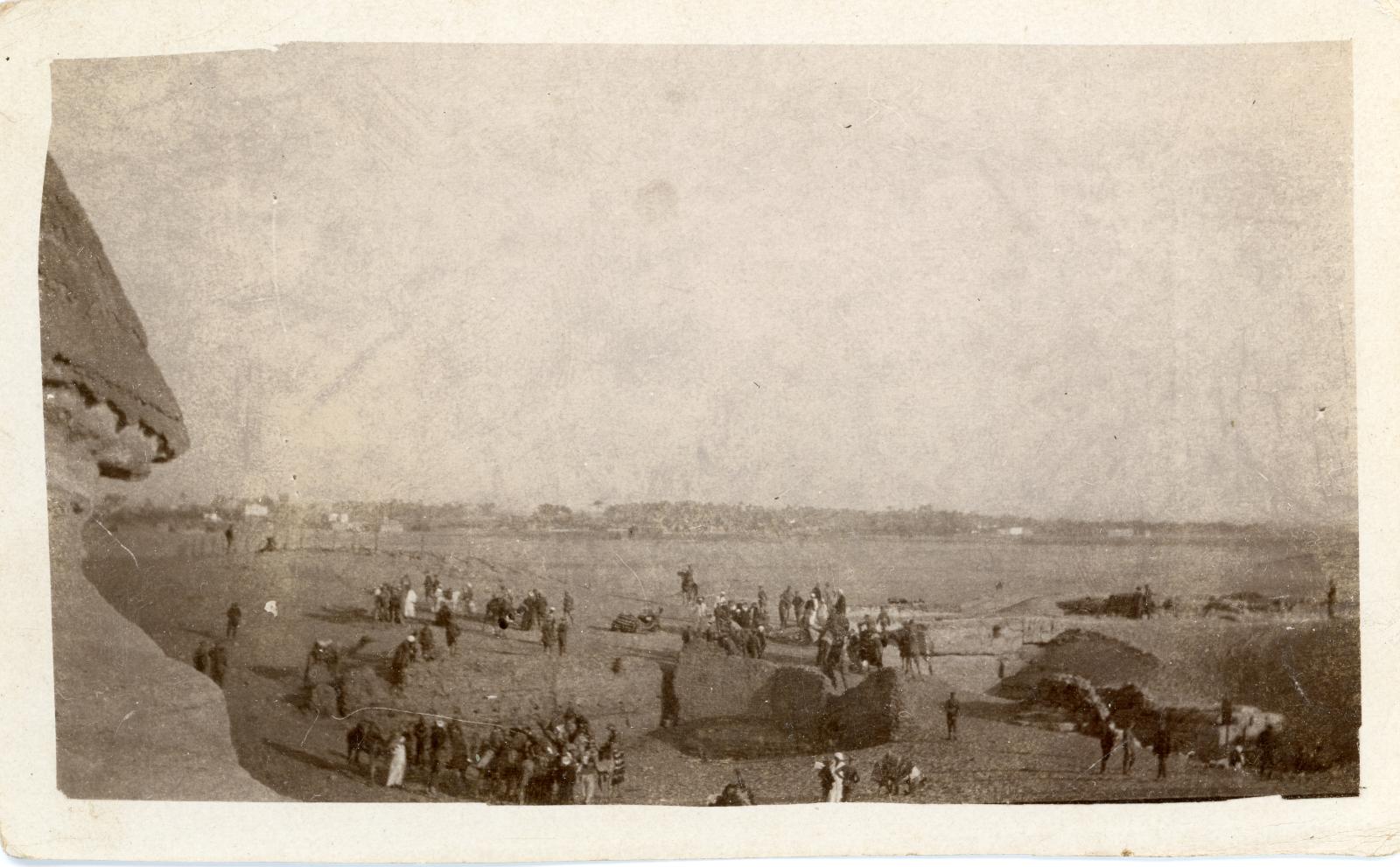 Photo of soldiers and locals sightseeing at the Giza Plateau, with side of the Great Sphinx on left.