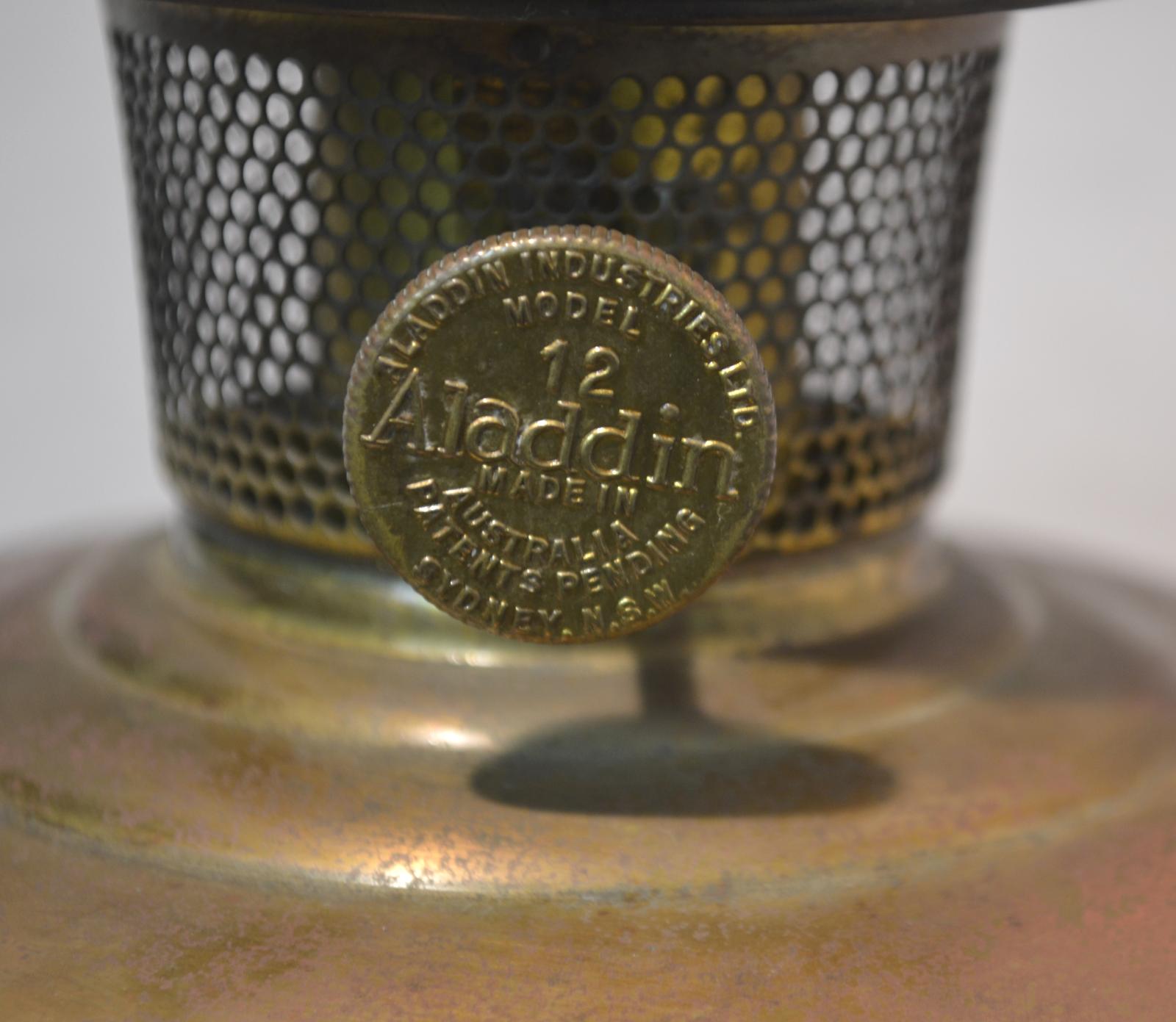 The wick control knob (a flat disc with a ridged rim) attached perpendicularly to a rod protruding from the perforated cage surrounding the wick.