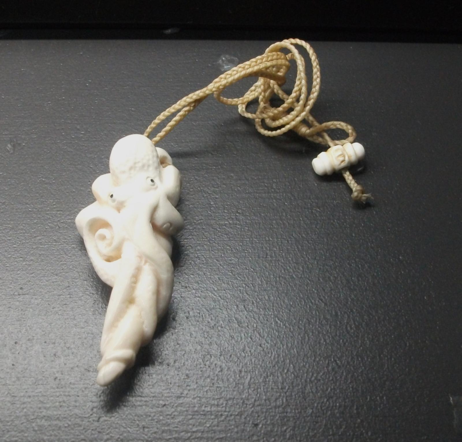 Carved whale's tooth into the shape of an octopus. Made in New Zealand.
