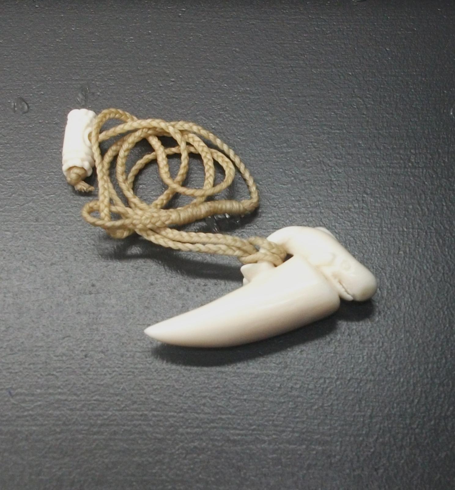 Whales tooth pendant with a carved sperm whale.