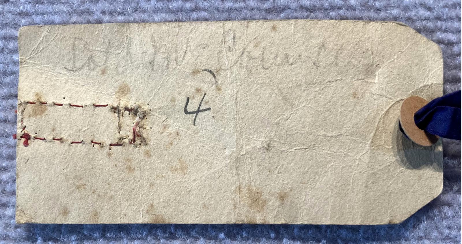 Close up of reverse of WWI era patriotic tag with ribbon and verse