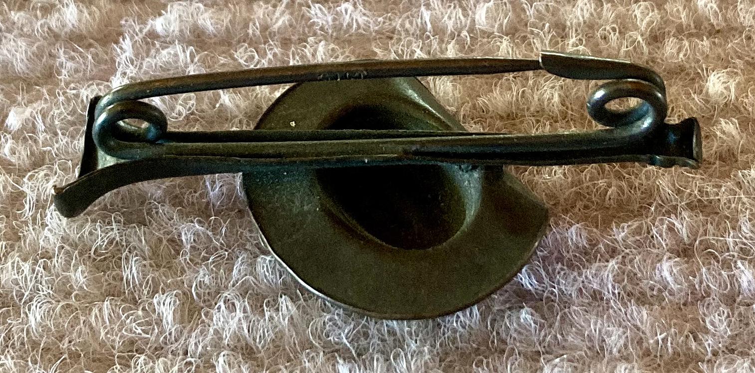 Oblique view of reverse of metal slouch hat mounted on bugle sweetheart brooch