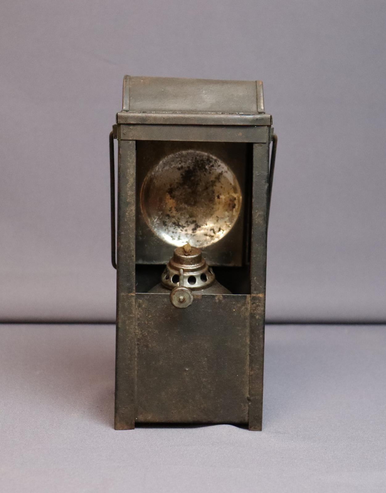 Rectangular metal case with rectangular window (no glass) frontside, top half. Inside the window is a concave, reflective piece of metal behind the burner.