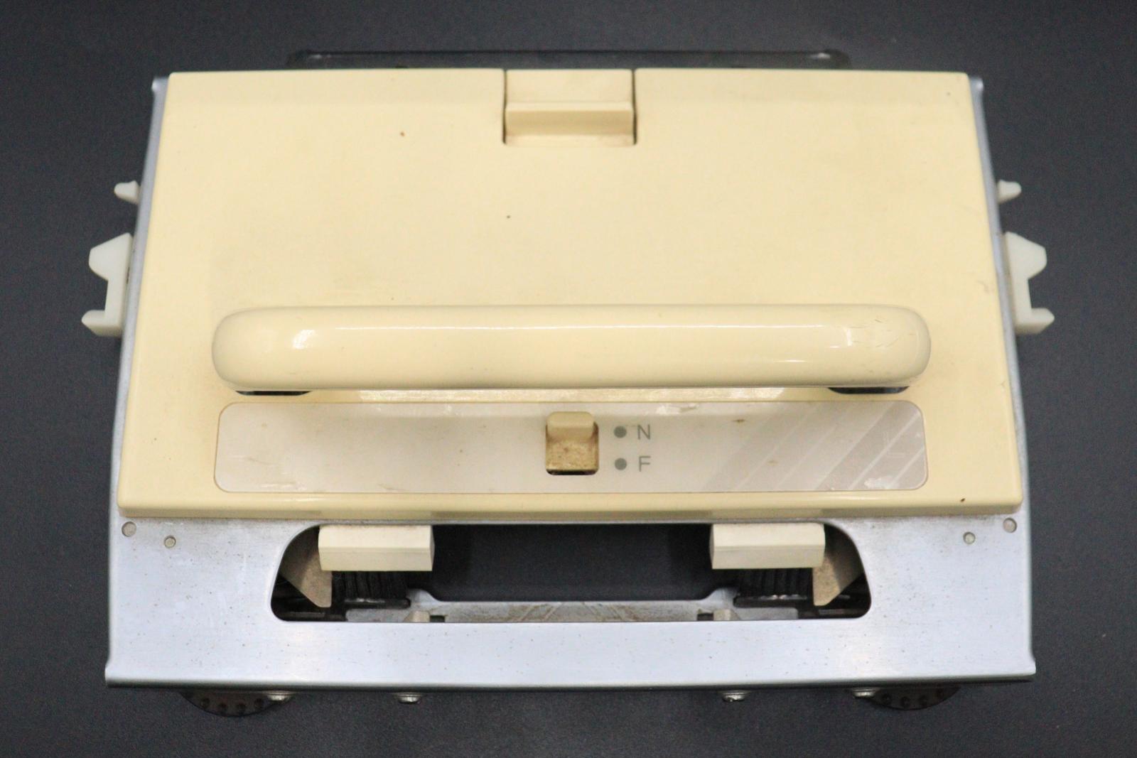 The rectangular cartridge for a BROTHER KH-892 Knitting Machine. Made of metal and cream-coloured plastic, approx. 25cm by 30cm, with a u-shaped handle on the top.