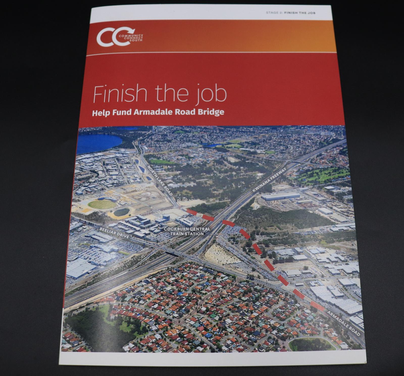 This brochure has white stripes on the top and bottom. In the orange rectangle, below the top-most white stripe, is a CC symbol, the second C is arrowed with the text [COMMUNITY/CONNECT/SOUTH]. Below that in the darker orange rectangle, is the text [FINISH THE JOB/ HELP FUND ARMADALE ROAD BRIFGE]. Below that is a photo of  Armadale Rd to Kwinana Freeway.