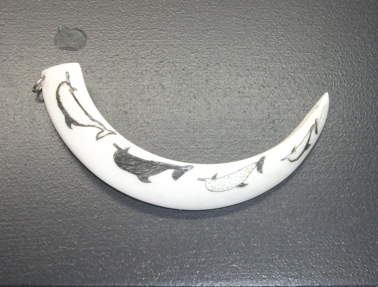 Small scrimshaw tusk depicting dolphins 