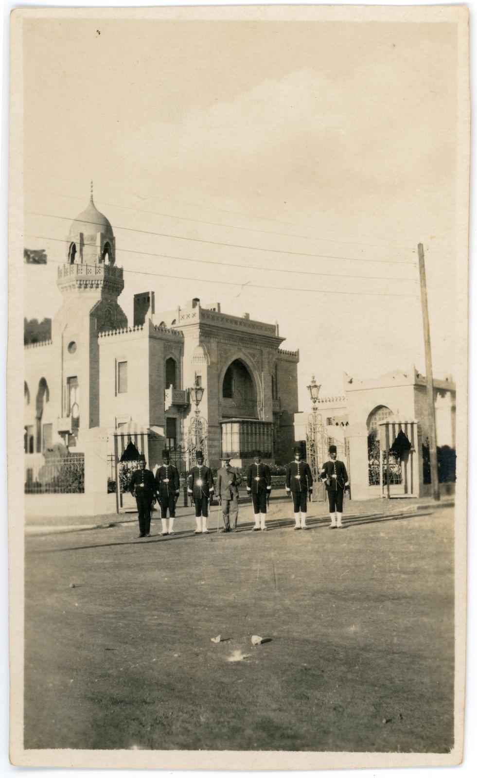 Photo of the Sultana Malak Palace, and uniformed guards and a tourist.