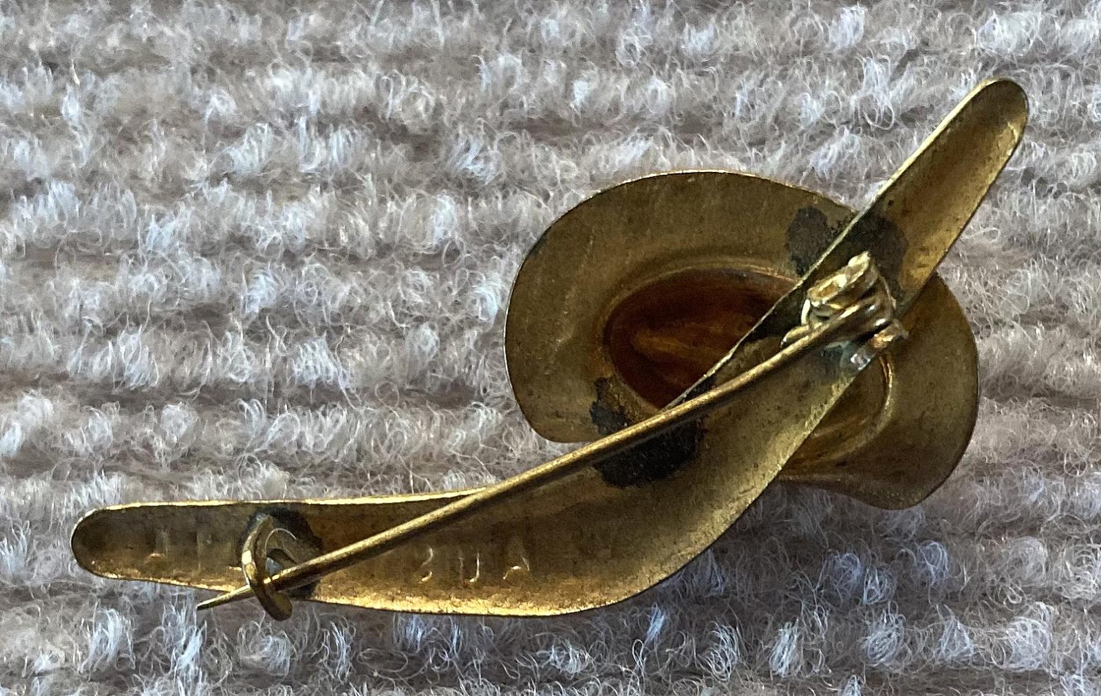 Angled view of reverse of gold tone patriotic brooch with slouch hat and boomerang