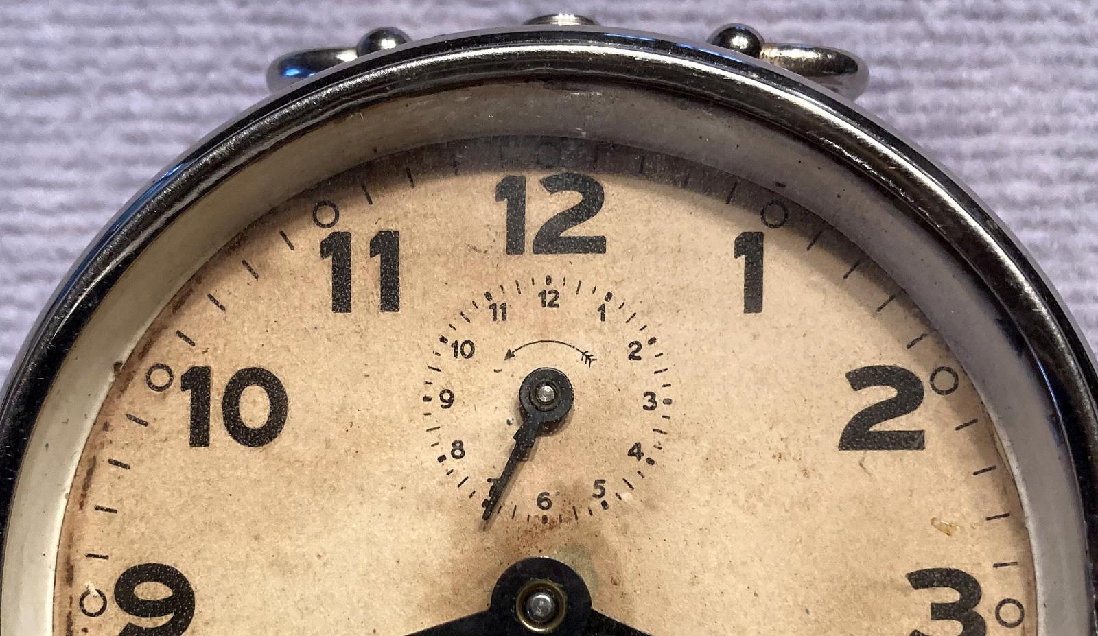 Close up of upper section of face of Commonwealth of Australia alarm clock 