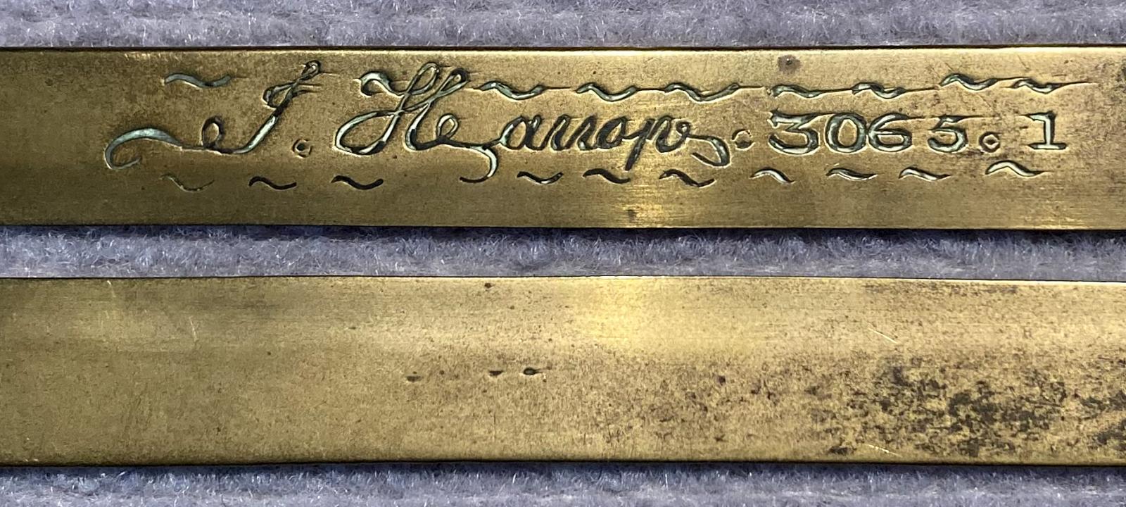 Close up of WWI era brass button stick engraved with name - J. Harrop