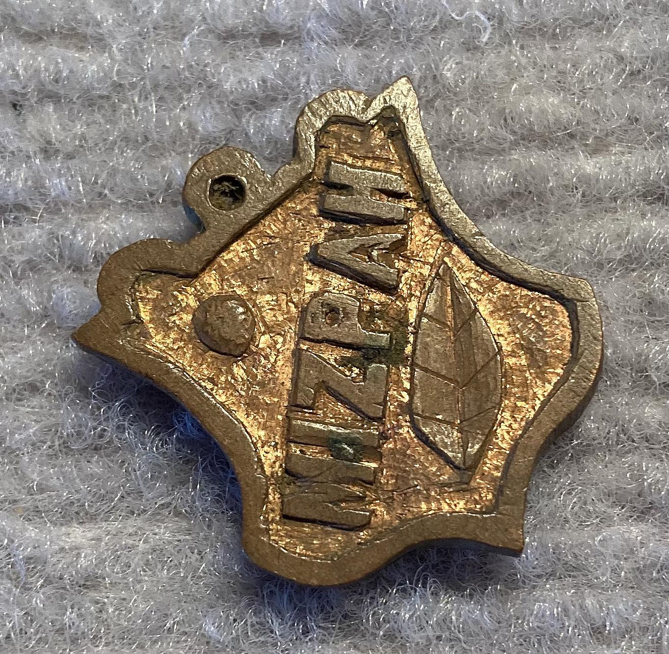 Angled view of gilded metal Mizpah sweetheart fob or pendant