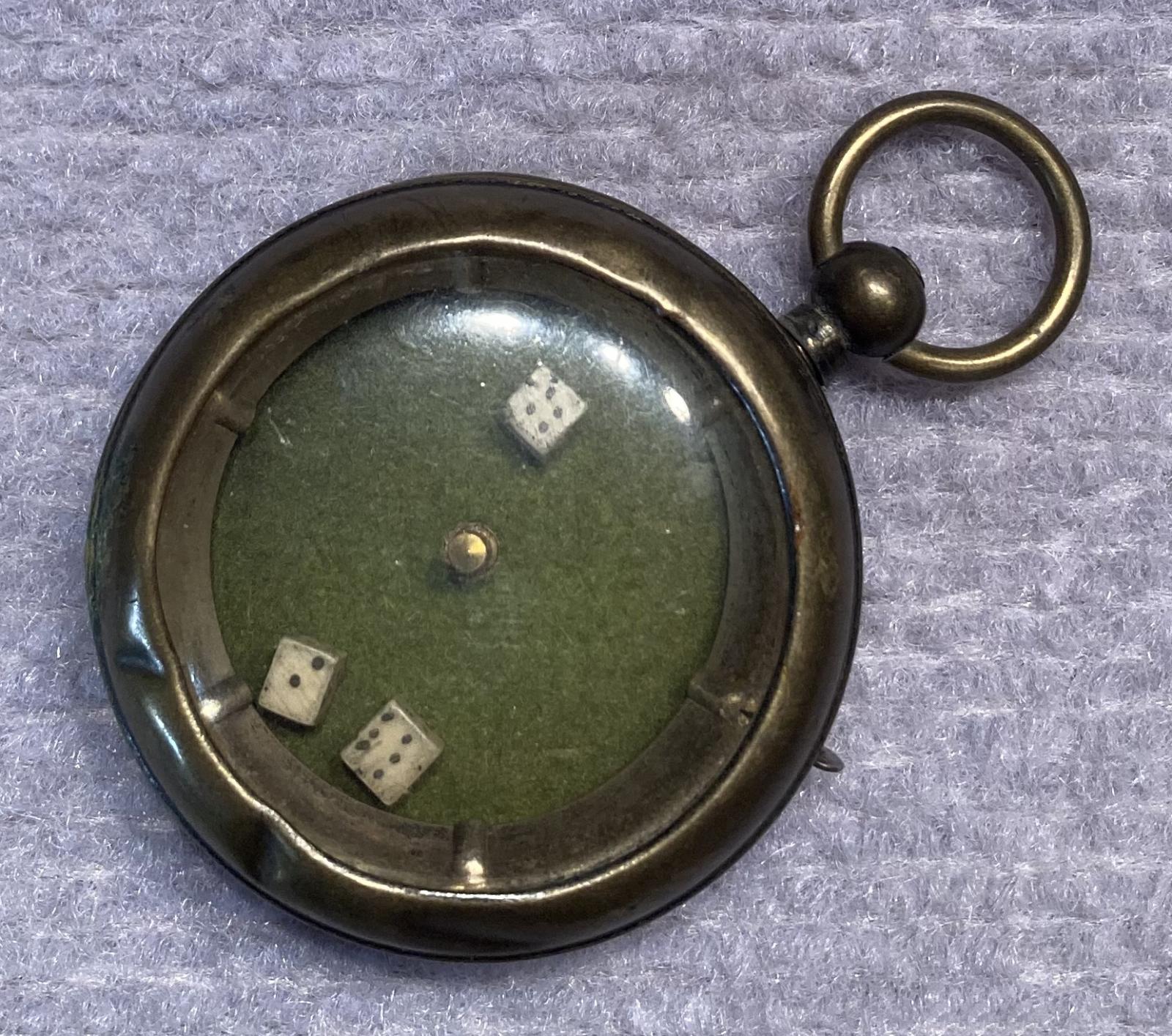 Other angled view of mechanical dice game encased in a pocket watch housing
