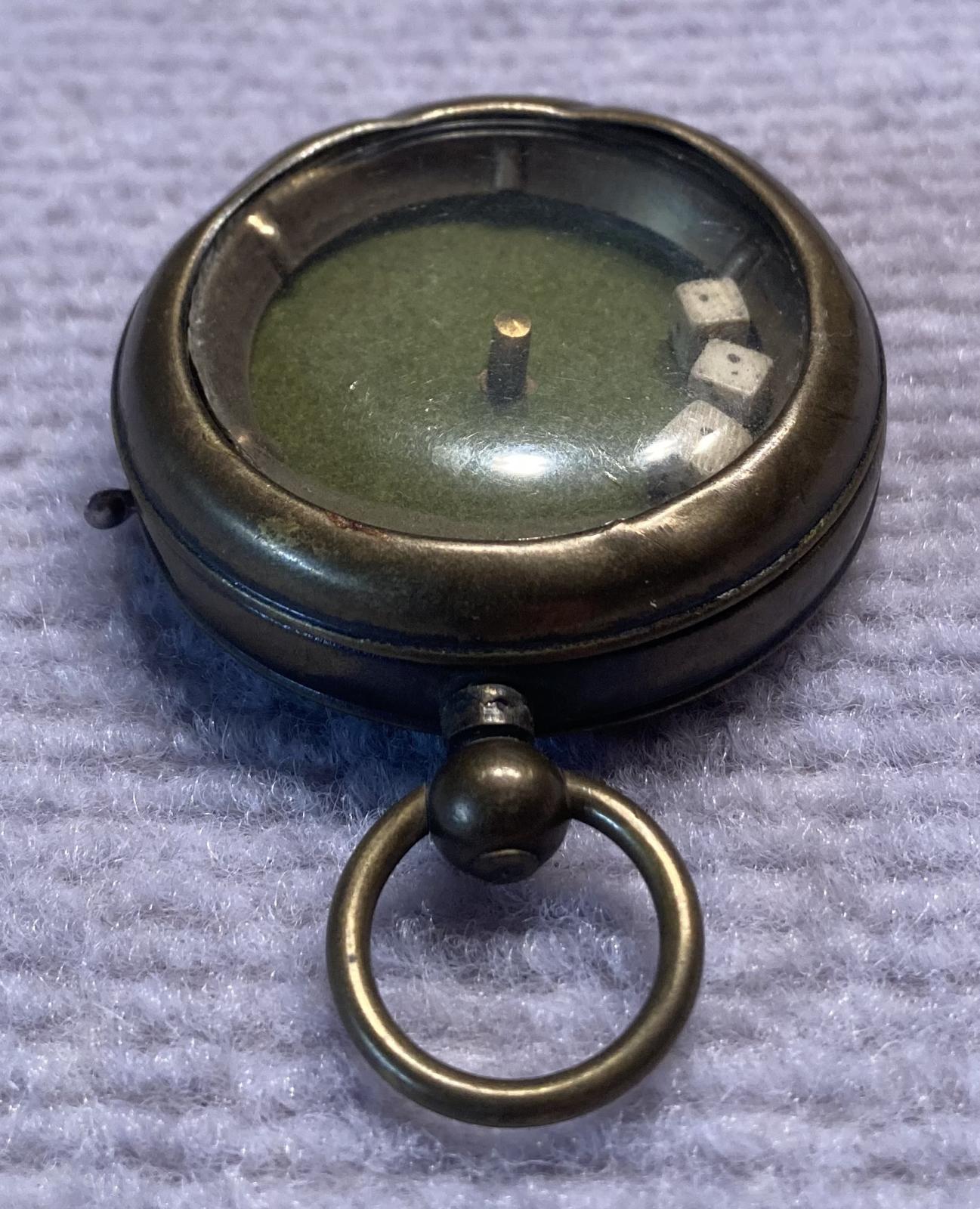 Other oblique view of mechanical dice game encased in a pocket watch housing